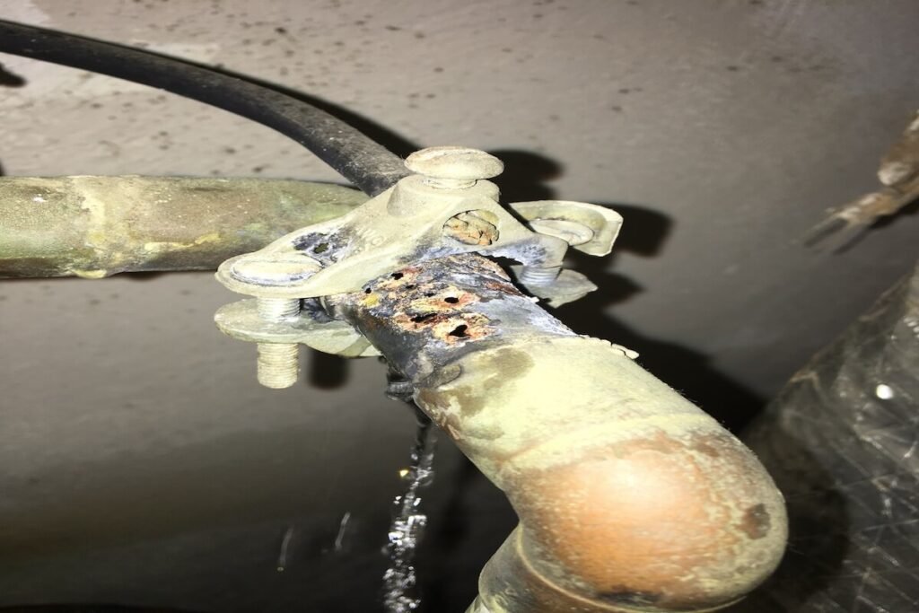 Lightning-damaged copper pipe leaking water inside a Virginia Beach home after an electrical strike caused a plumbing failure.